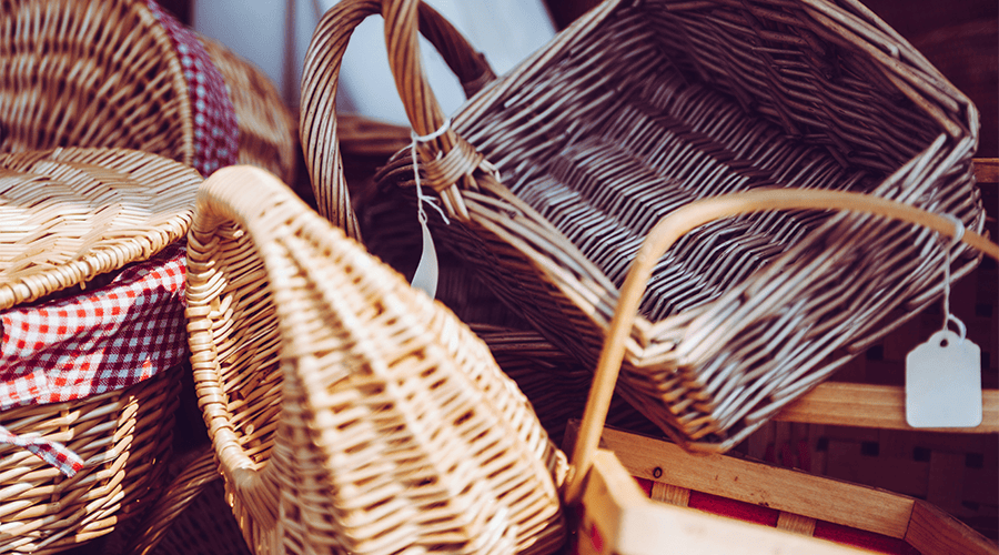 A range of wedding guest hampers in different colours and sizes including some with red and white checked detail and another with a white tag.